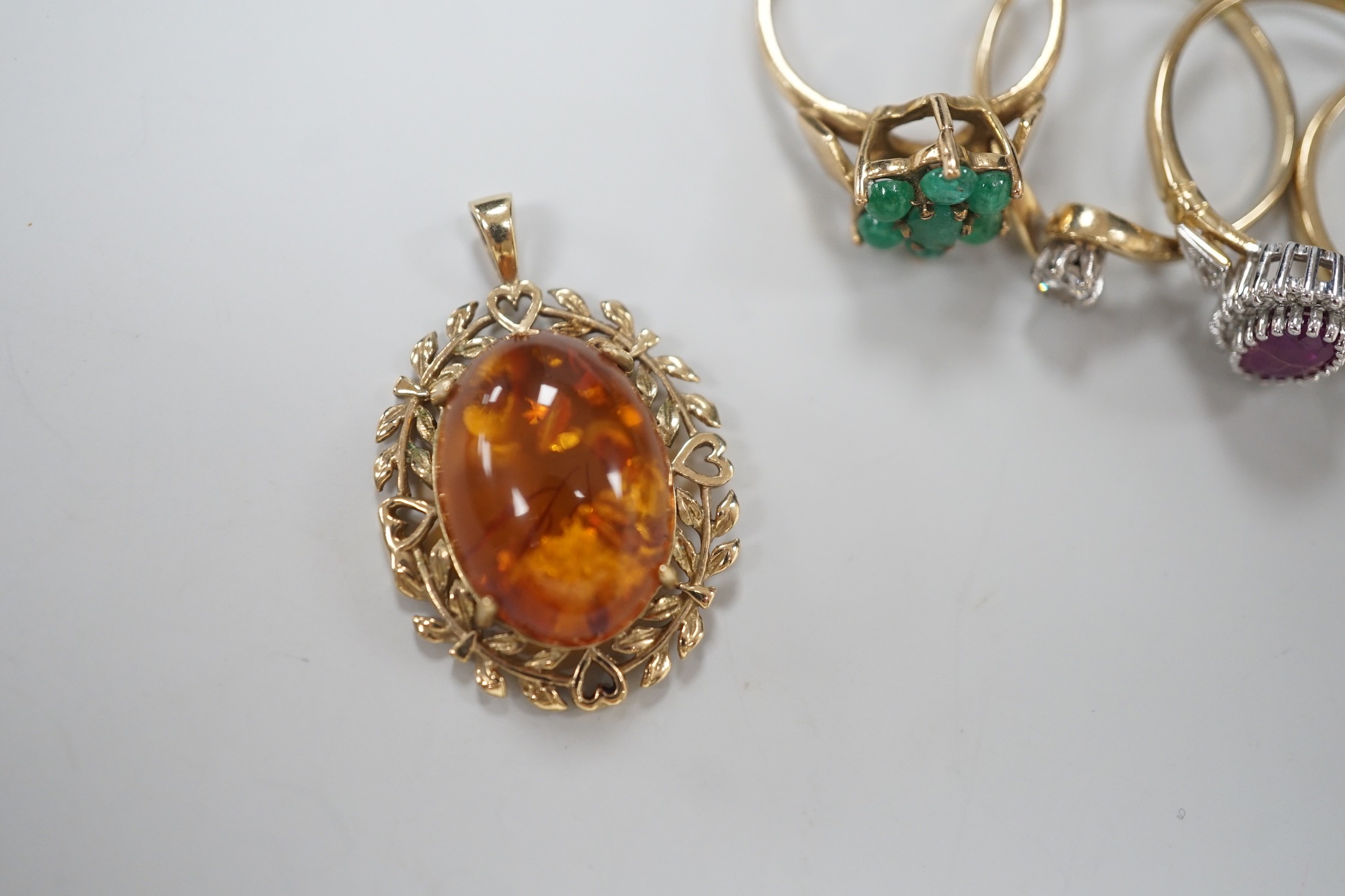 Seven assorted modern 9ct gold and gem set rings, including two solitaire diamond rings, together with a 9ct gold and amber set pendant, gross weight 19.3 grams.